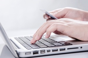 pessoa-utilizando-notebook-com-cartao-em-maos.jpg